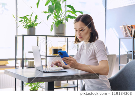 Young beautiful woman sitting at desk with laptop working remotely in coworking space Young beautiful woman sitting at desk with laptop working remotely in coworking space 119184308