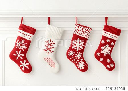 Festive Christmas stockings adorned with snowflakes on a white mantelpiece Festive Christmas stockings adorned with snowflakes on a white mantelpiece 119184936