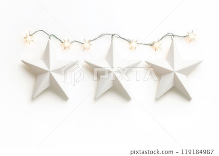 Decorative white Christmas stars with golden accents and fairy lights on white background. Festive holiday decor concept Decorative white Christmas stars with golden accents and fairy lights on white background. Festive holiday decor concept 119184987