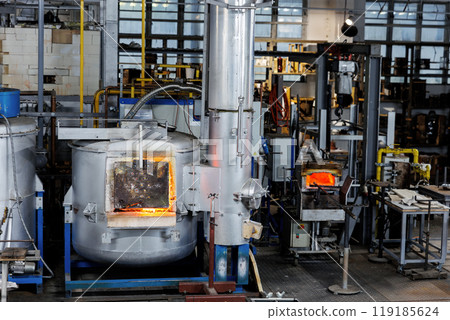 Industrial glassblowing furnaces actively running in glassware factory.  Glowing heat of glassmaking process. Handmade blowing glassware design production manufacture Europe 119185624
