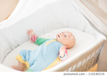 Cute baby boy in a white crib Cute baby boy in a white crib 119186534