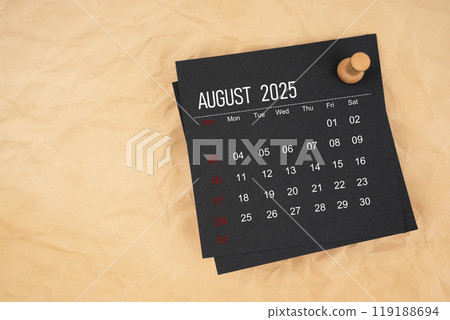 Black calendar sheet for August 2025 with thumbtack on brown paper crumpled. 119188694