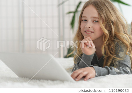 girl in the nursery draws lying on the carpet. girl in the nursery draws lying on the carpet. 119190083
