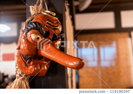 Red Japanese Tengu Mask hang on wood pillar in Japanese building Red Japanese Tengu Mask hang on wood pillar in Japanese building 119190397