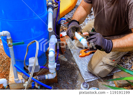 Plumber is assembling connection service between well water system in house. Plumber is assembling connection service between well water system in house. 119191199