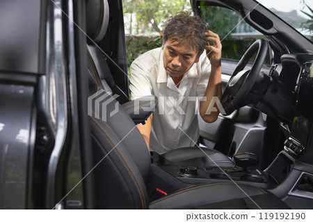 Senior asian man loking for the forgot key inside car. Senior asian man loking for the forgot key inside car. 119192190