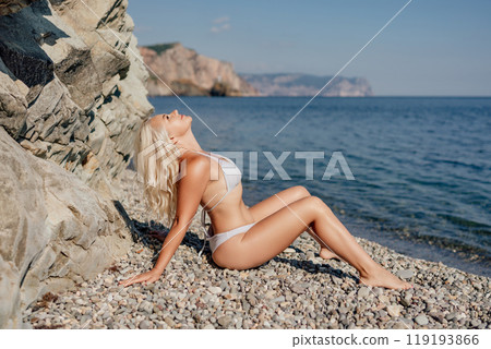 A woman is laying on the beach in a bikini 119193866