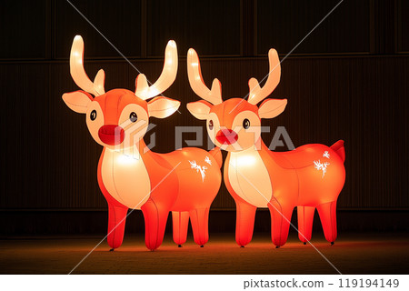 Two large inflatable reindeer glowing in the dark, snowy background, concept of festive decorations Two large inflatable reindeer glowing in the dark, snowy background, concept of festive decorations 119194149