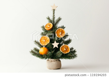 Creative composition of ornaments, pinecones and dried fruits on green branches, ideal for Christmas holiday decorations 119194203