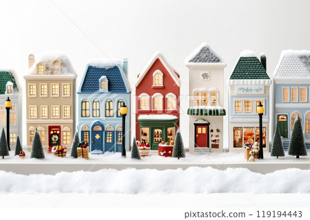 Miniature winter village with various houses, trees, and figurines on a white snowy background. Festive holiday decor 119194443