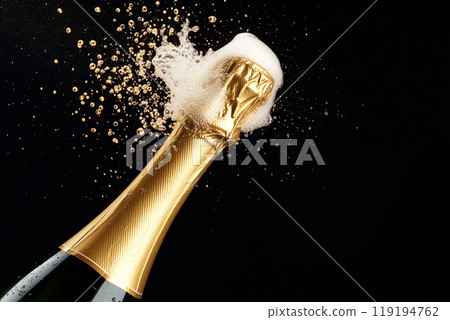 Champagne bottle popping with foam and bubbles against black background. Celebration, festive, and luxury concept Champagne bottle popping with foam and bubbles against black background. Celebration, festive, and luxury concept 119194762