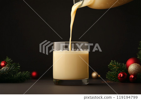 A glass of eggnog being poured with a pine branch and pine cone on a light background. Holiday drink concept A glass of eggnog being poured with a pine branch and pine cone on a light background. Holiday drink concept 119194799