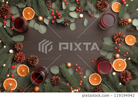 Christmas wreath with mulled wine and dried orange slices on a dark wooden background. Festive decorations 119194942