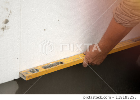 builder installs polystyrene foam sheets. builder installs polystyrene foam sheets. 119195255