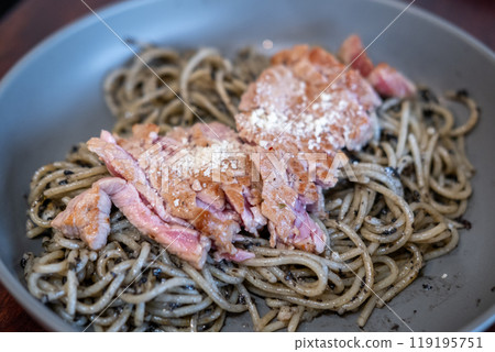 Spaghetti with truffle sauce, grilled meat on the top, served on plate Spaghetti with truffle sauce, grilled meat on the top, served on plate 119195751