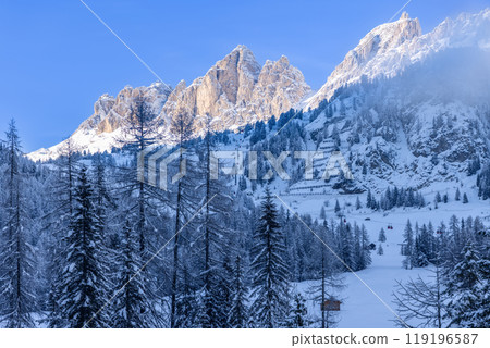 Dolomites in Alto Adige with ski lifts, snowy peaks, and sunlit slopes contrasting beautifully 119196587