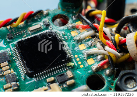 Close-up macro of drone flight controller microprocessor with broken wire. Microelectronics repair. Close-up macro of drone flight controller microprocessor with broken wire. Microelectronics repair. 119197226