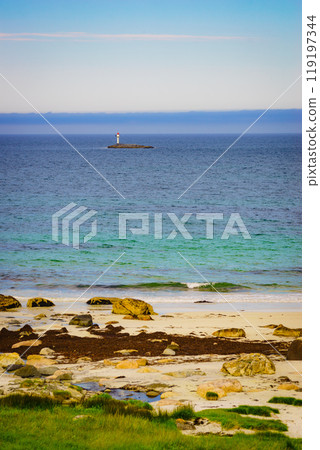 Seascape sandy beach with lighthouse on horizon 119197344