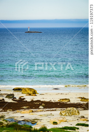 Seascape sandy beach with lighthouse on horizon 119197373