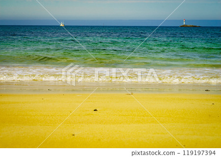 Seascape sandy beach with lighthouse on horizon 119197394