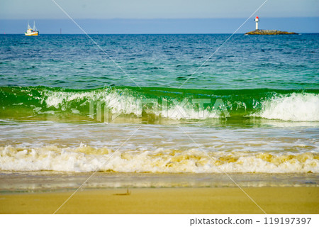 Seascape sandy beach with lighthouse on horizon Seascape sandy beach with lighthouse on horizon 119197397