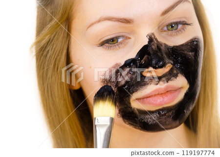 Girl being apply black mask to skin face 119197774