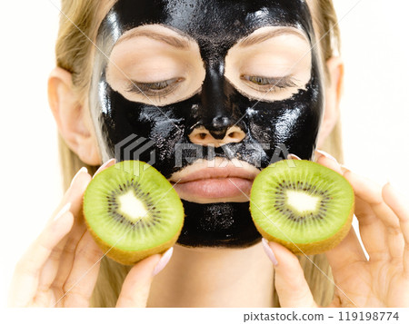 Girl black mask on face holds kiwi fruit 119198774