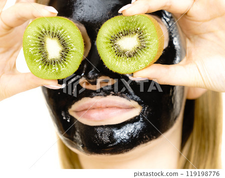Girl black mask on face holds kiwi fruit 119198776