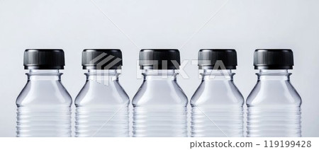 Row of Empty Clear Plastic Bottles with Black Caps 119199428