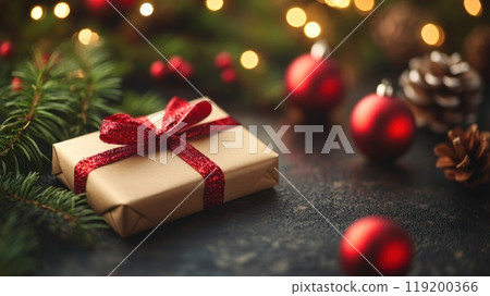A brown box with a red ribbon and pine cones on top of it 119200366