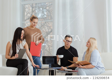 A group of people are sitting on a sofa and discussing work issues A group of people are sitting on a sofa and discussing work issues 119200654
