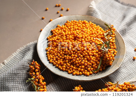 A plate with berries stands on a table with a gray napkin 119201324