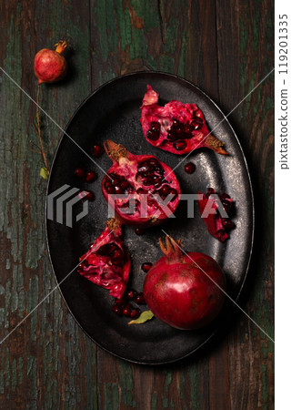 Pomegranate fruit in a black metal tray on a wooden background Pomegranate fruit in a black metal tray on a wooden background 119201335