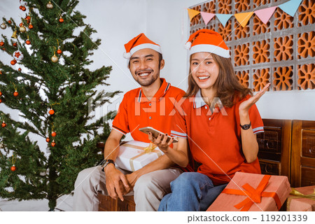 A Festive Couple Together Joyfully Celebrating Christmas with Gifts and Cheer A Festive Couple Together Joyfully Celebrating Christmas with Gifts and Cheer 119201339