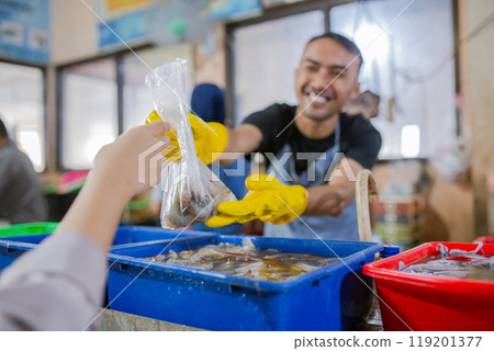 Engaging Encounter at a Colorful and Vibrant Seafood Market with a Smiling Vendor 119201377