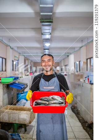 Fresh Catch A Smiling Fishmonger Welcoming Customers at a Vibrant Fish Market 119201379