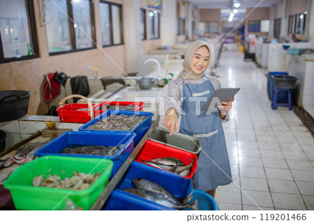 A Worker at the Fresh Seafood Market is Sorting Various Fish and Shrimp Types A Worker at the Fresh Seafood Market is Sorting Various Fish and Shrimp Types 119201466