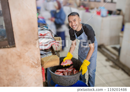 A Smiling Worker is Preparing Fresh, Delicious Seafood in a Busy Market Setting A Smiling Worker is Preparing Fresh, Delicious Seafood in a Busy Market Setting 119201486