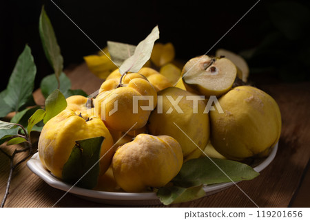 Ripe quince fruits on a plate on a wooden table Ripe quince fruits on a plate on a wooden table 119201656