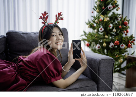 woman holding blank screen phone christmas holiday 119201697