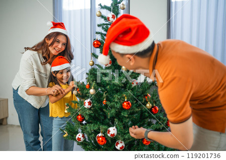 little family having fun decorating christmas tree 119201736