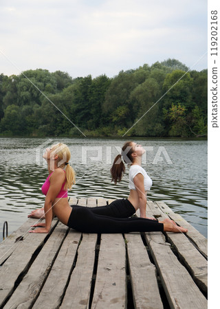 Two teenage girls perform a stretching exercise Two teenage girls perform a stretching exercise 119202168