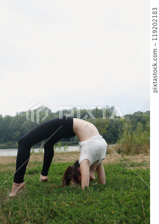 A teenage girl is doing a handstand on the training ground 119202183