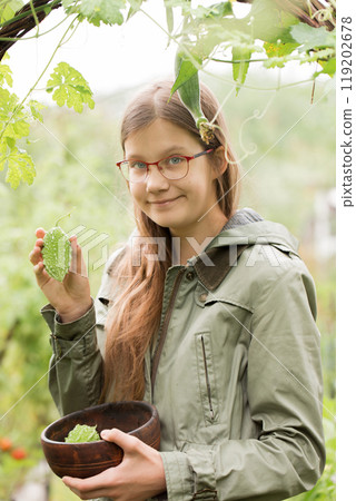 Portrait of a teenage girl with a momordica fruit in the garden Portrait of a teenage girl with a momordica fruit in the garden 119202678
