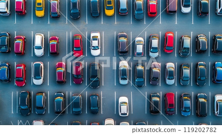 An aerial view of a crowded parking lot with cars neatly lined up, demonstrating patterns and organization in public parking areas 119202782