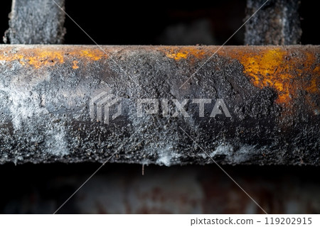 Close-up of a dirty, corroded pipe with rust and grime buildup 119202915