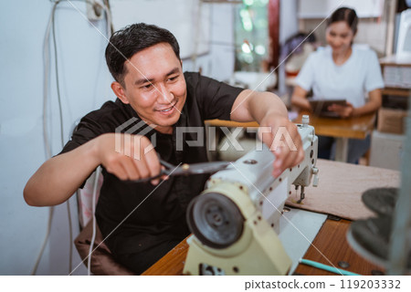 asian male tailor cutting the yarn while producting the curtain 119203332