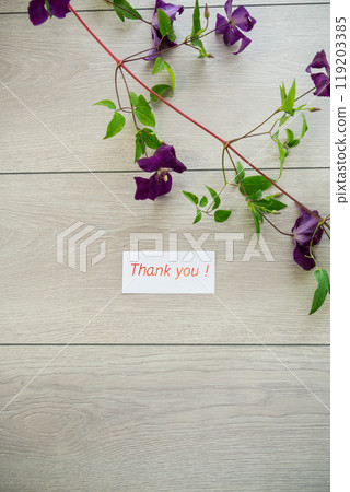 branch of blooming purple clematis, on a light wooden table branch of blooming purple clematis, on a light wooden table 119203385
