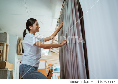 asian production crew putting he curtain on hanger to setting the wave 119203447