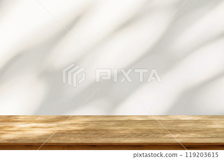 Empty wood table top on beige wall texture with tree leaves shadow background Empty wood table top on beige wall texture with tree leaves shadow background 119203615
